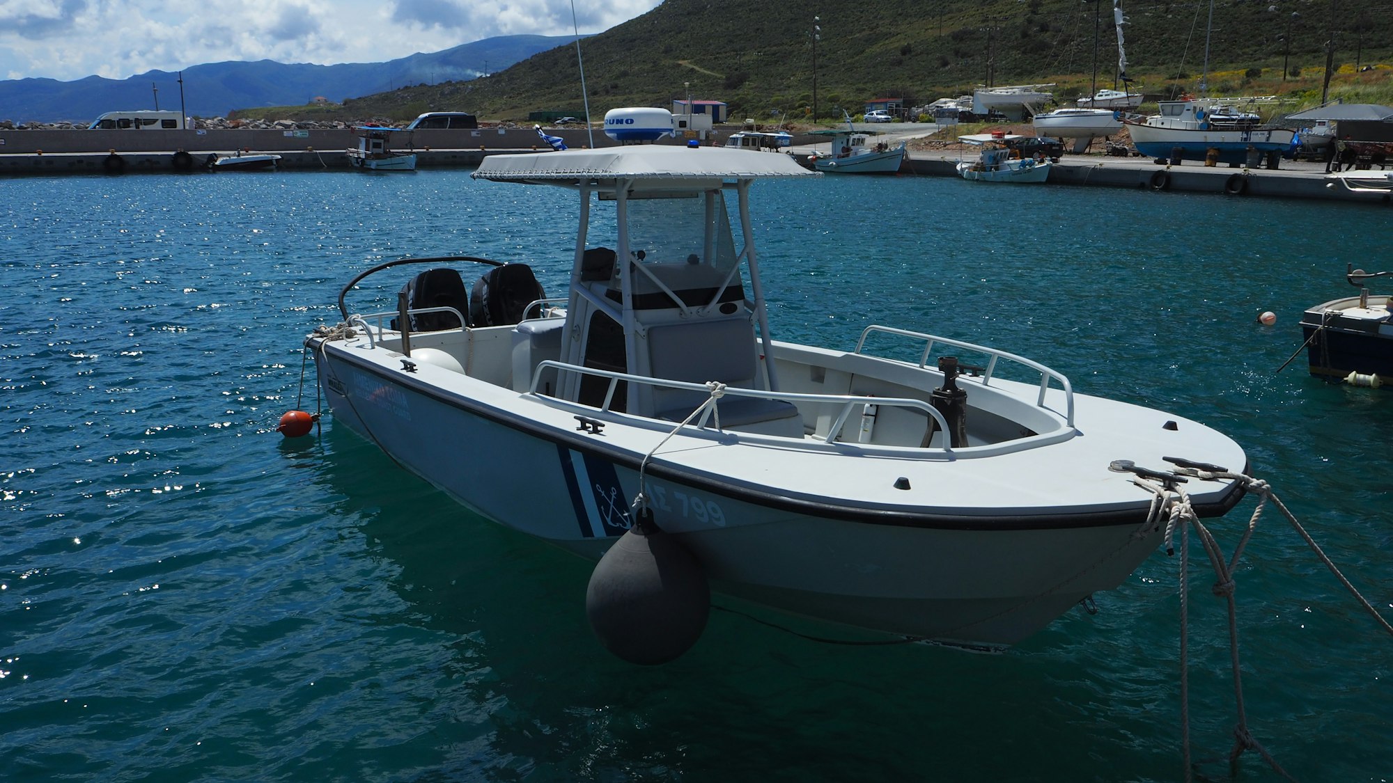 A small white boat on dark open water