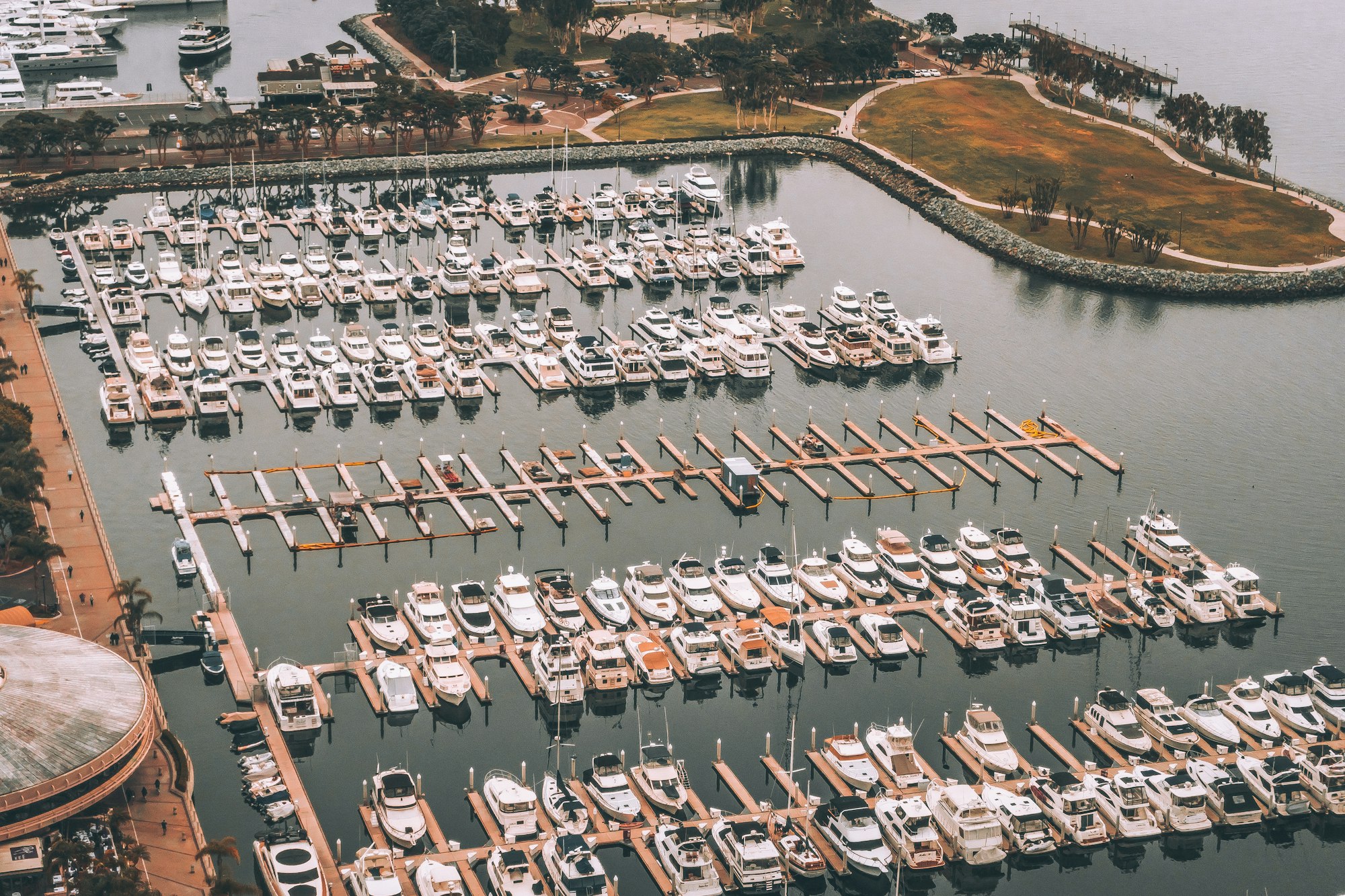Aerial view of a marina packed with moored boats on dark water
