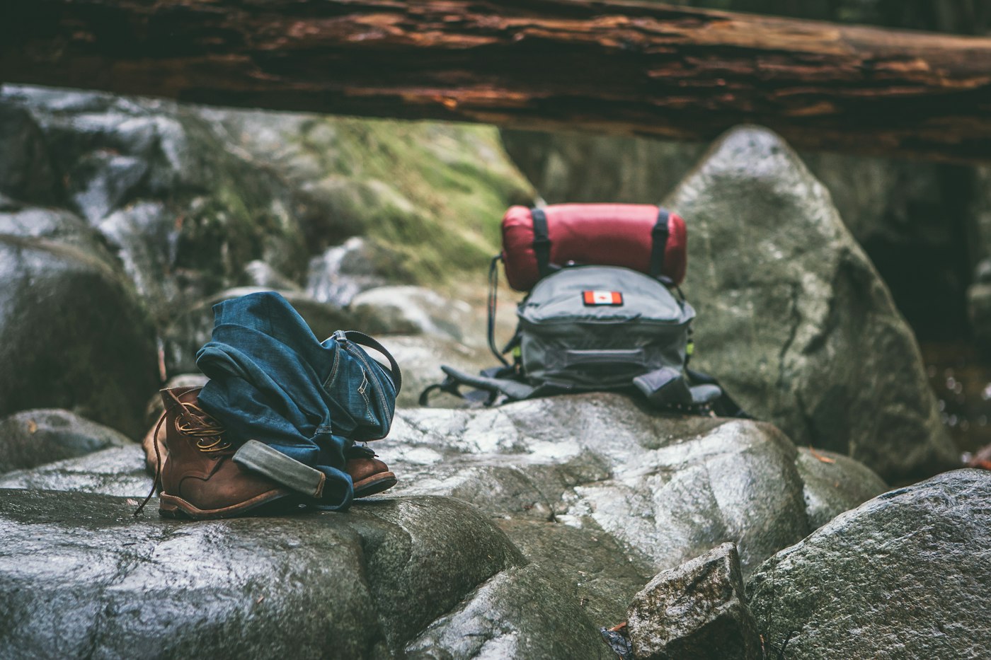 Two backpacks resting on gray rocks