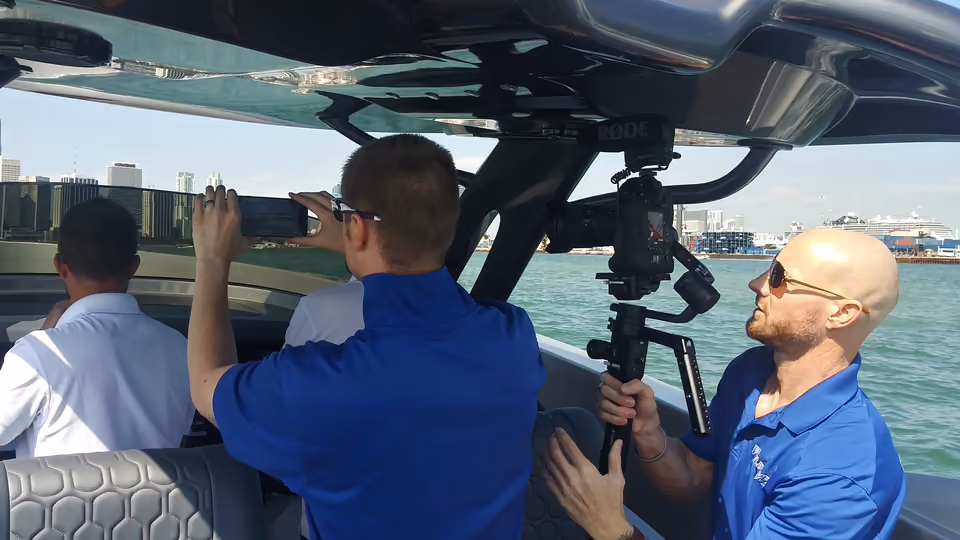 The MediaWyld crew filming from a boat on Biscayne Bay with the Miami skyline behind