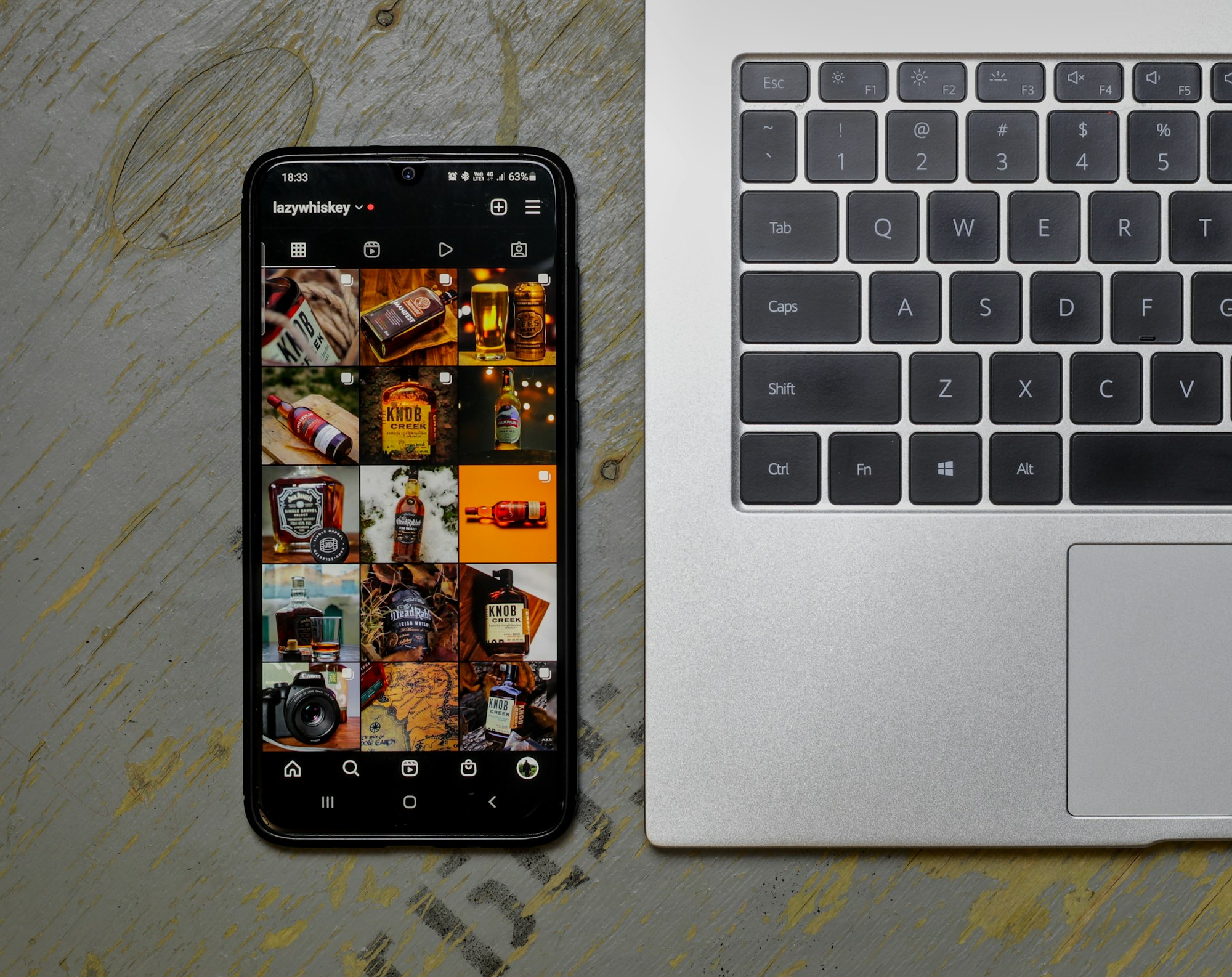 A laptop beside a phone with social media open